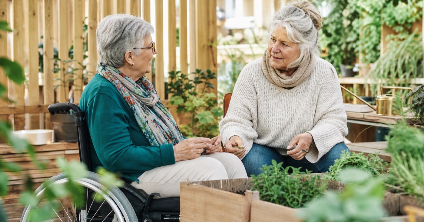 Zwei ältere Frauen begegnen sich auf Augenhöhe im Gemeinschaftsgarten